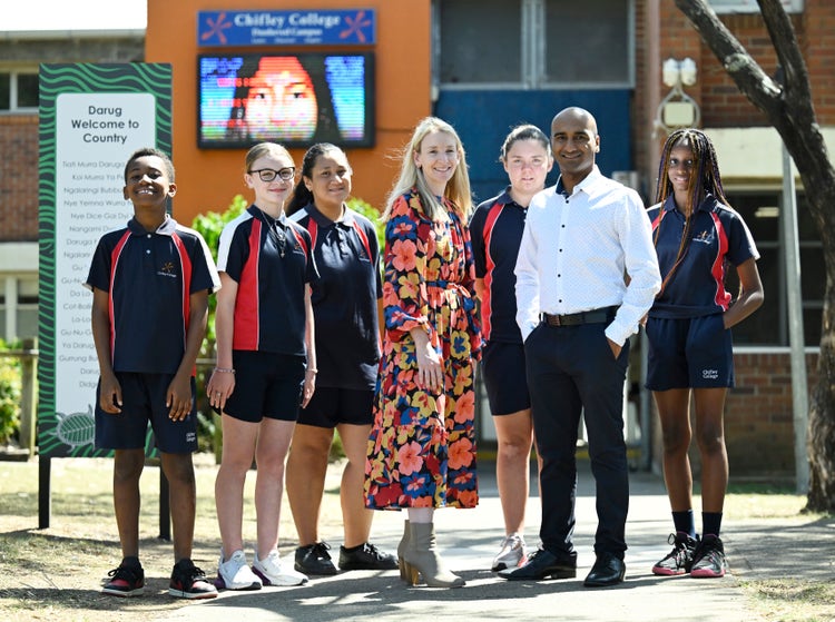 Staff and students standing at the front of the school