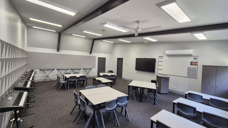 Classroom with tables and chairs, technology and keyboards around the room